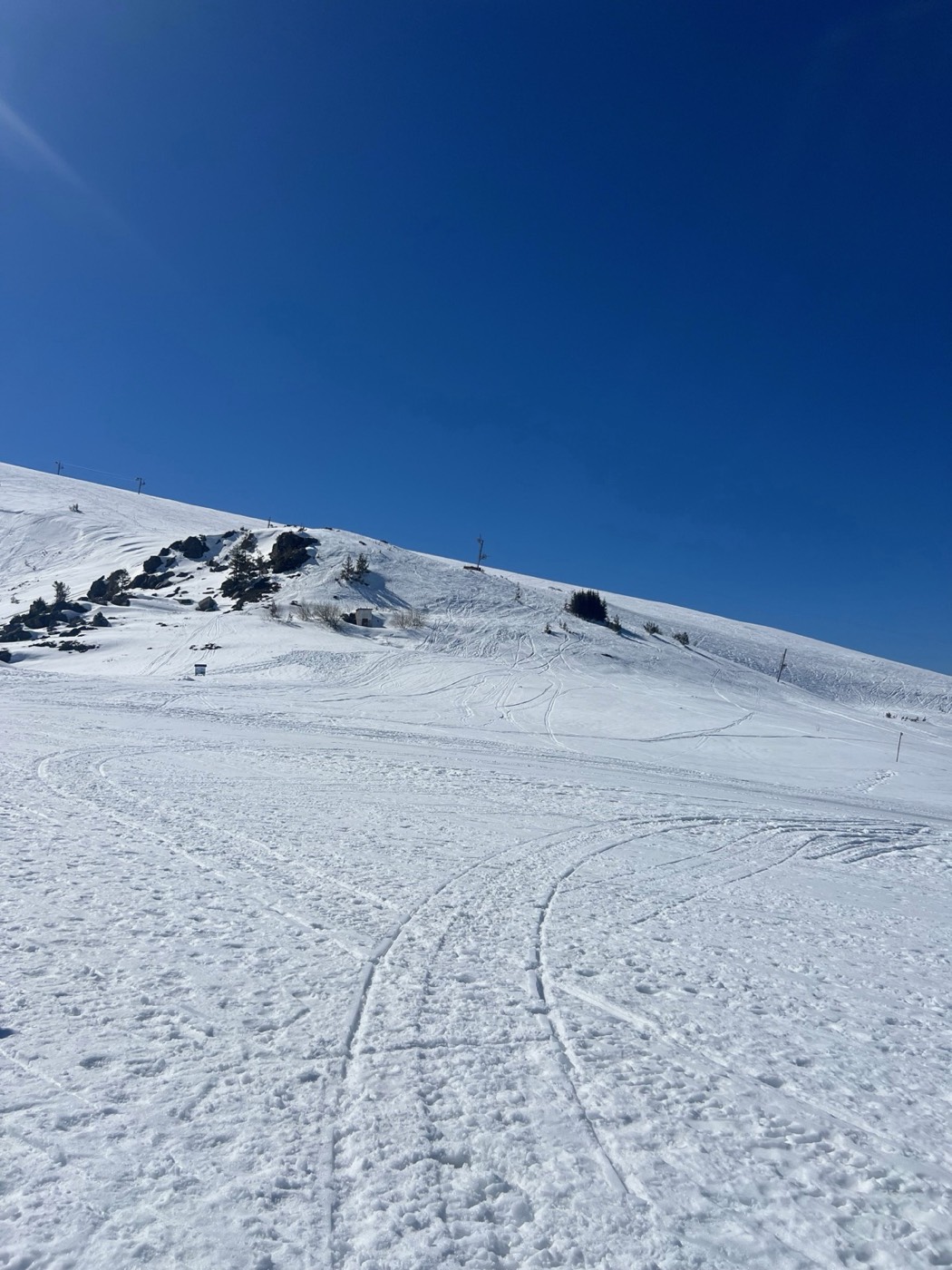 Open snowfield under a deep blue mountain sky