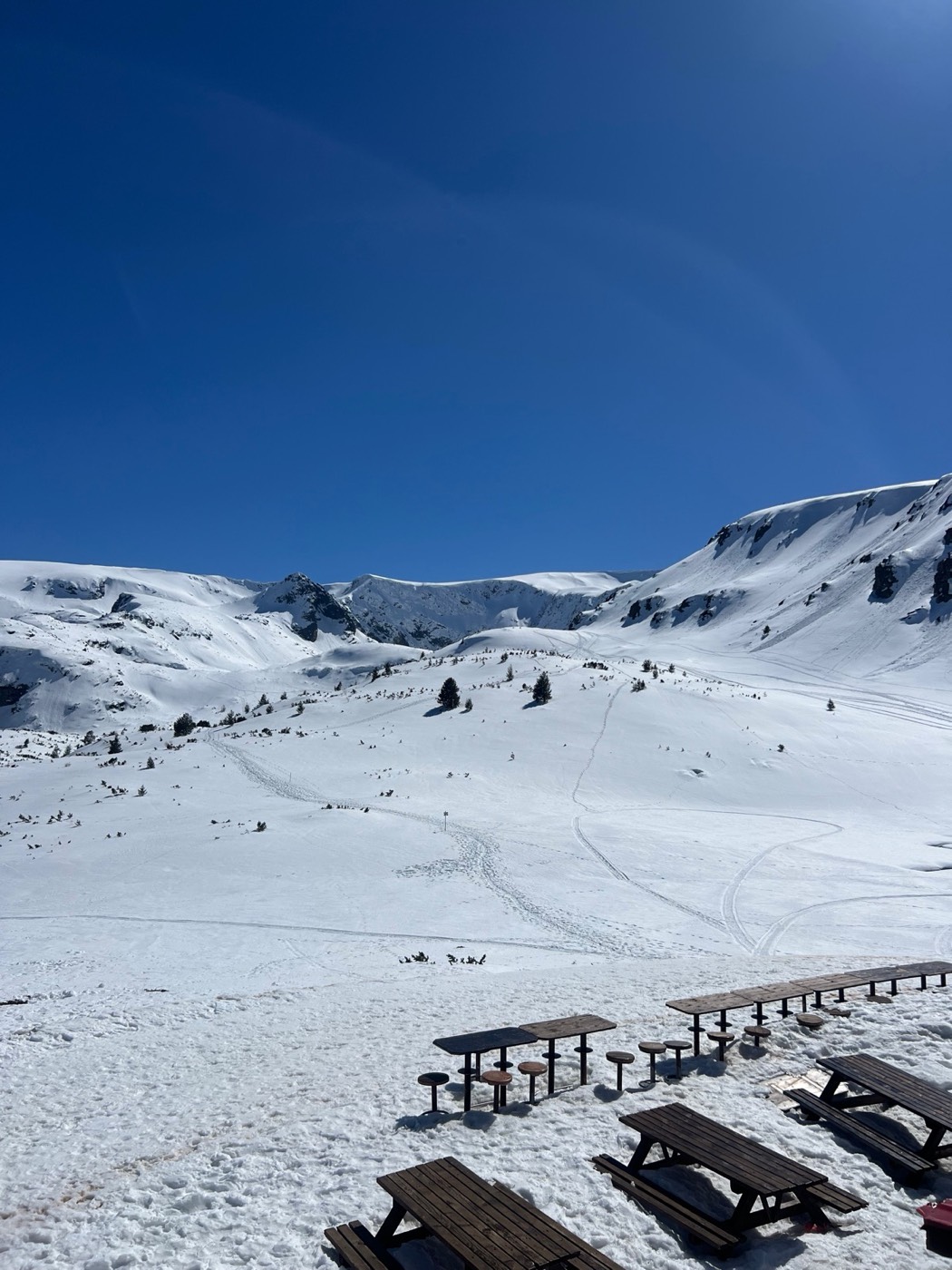 Wide snowy slopes in the Rila Mountains beneath a blue sky